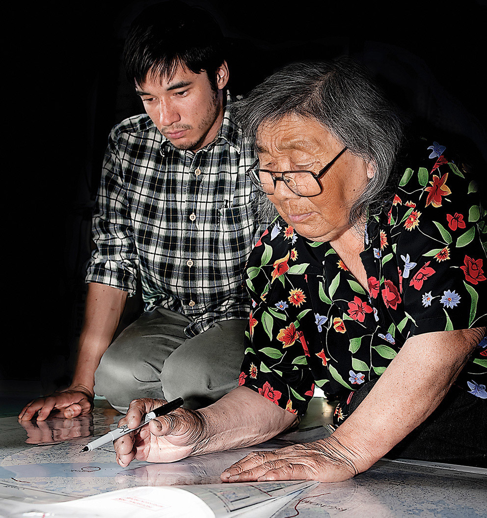 Indigenous people Edith Hogak and James Kuptana poring over regional maps.
