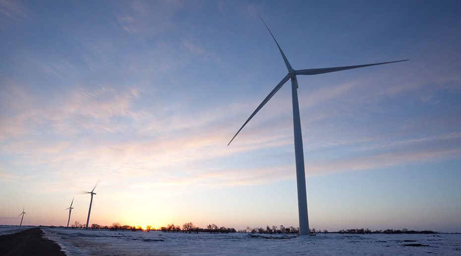 Vue en perspective d'une éolienne sur un soleil couchant.