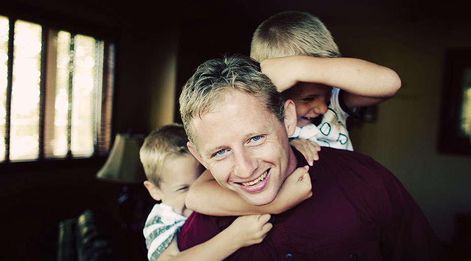 Rick Ralph and his 2 children posing for a photo inside a house.