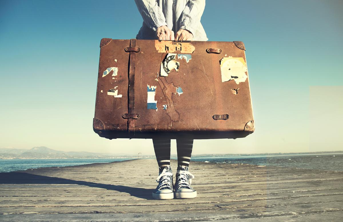 A picture of a person holding a briefcase with both hands.