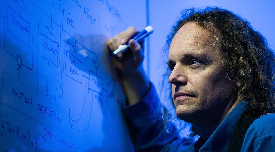 University of Waterloo direcotr Chris Eliasmith sketching equations on a whiteboard.