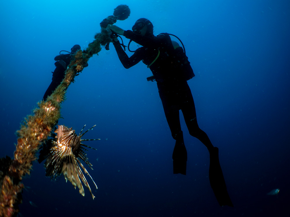 2 divers securing a device on the seabed.