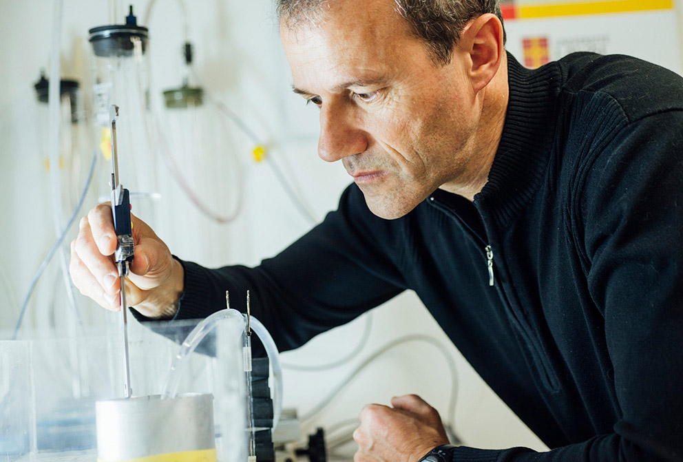 Le professeur Jean Caron utilisant des outils dans un laboratoire.