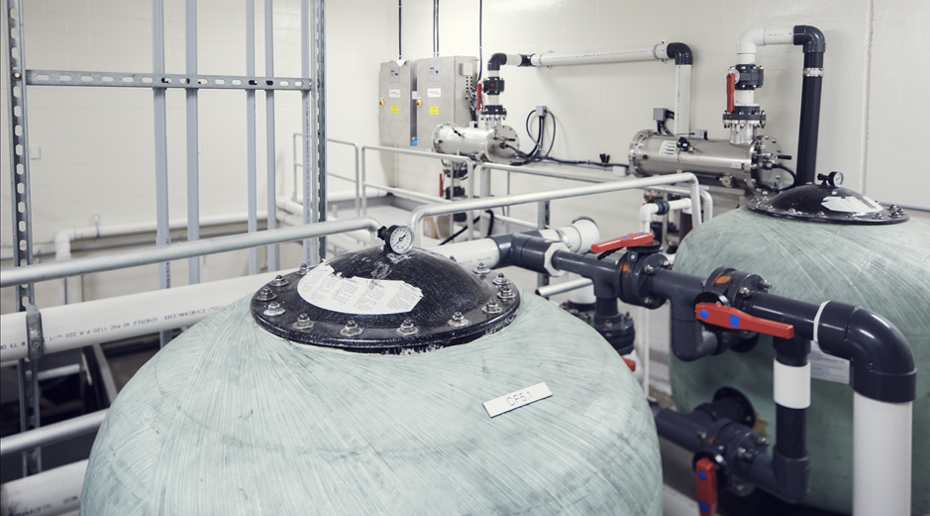 2 concrete tanks connected by a pipe system inside a white room.