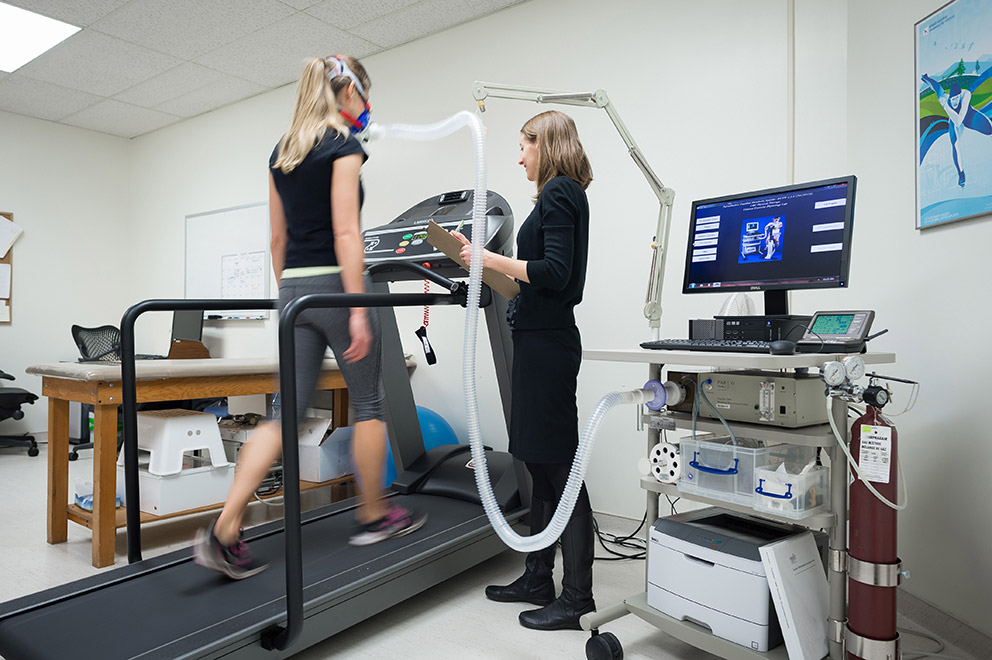 Researcher Kristin Campell monitoring a treadmill walker during a aerobic fitness test.