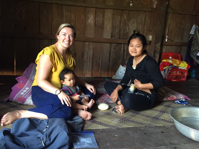 Researcher Kyly Whitfield holds an infant on her lap while their mother pumps breastmilk