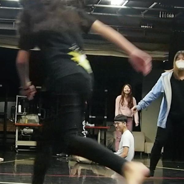 Des élèves d’art dramatique en mouvement sur une scène.