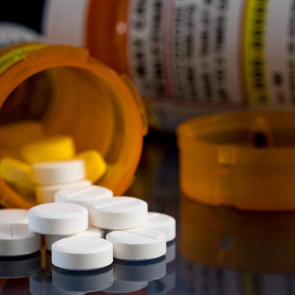 Prescription pill bottles tipped over with white tablets poured out