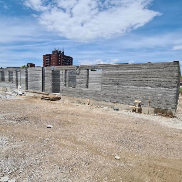 The cement walls of a partially built building viewed from the side.