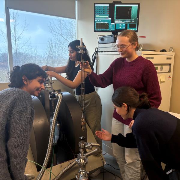 A person holds a long probe while another prepares another piece of equipment in the background.