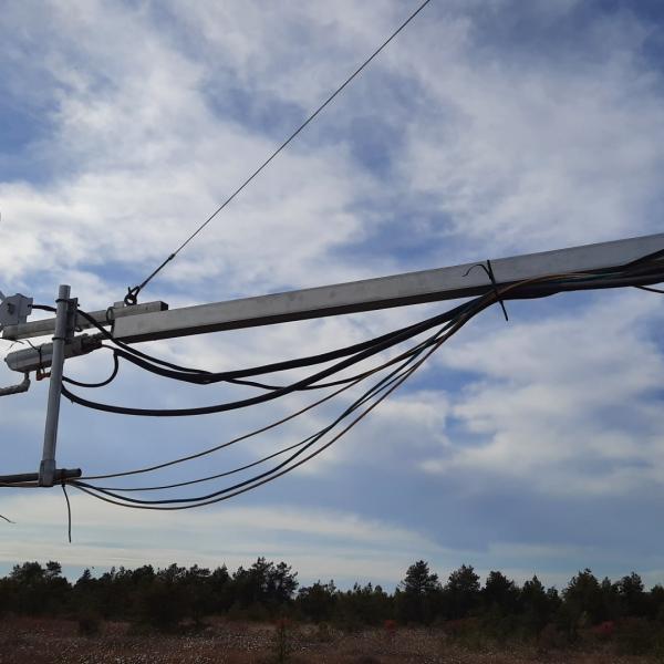 Un bras métallique muni d’instruments de recherche s’étend depuis une tour surplombant une tourbière.