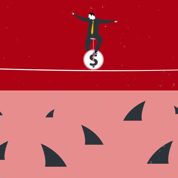 Illustration of a man in a grey suit sitting on a unicycle with a dollar sign on it. He is balancing on a tightrope and looking down at the shark fins darting out of the water below. The sharks are waiting for him to fall.