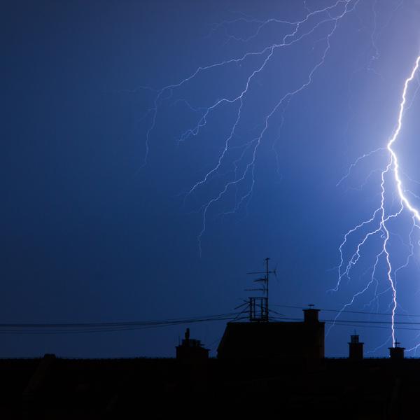 Lightning arcs between two skyscrapers in a nighttime city scape