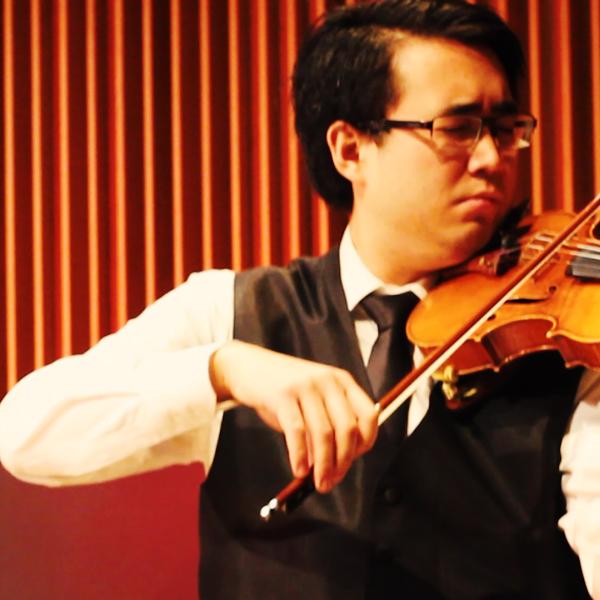 Graduate student Ewald Cheung plays the violin in McGill University music hall.