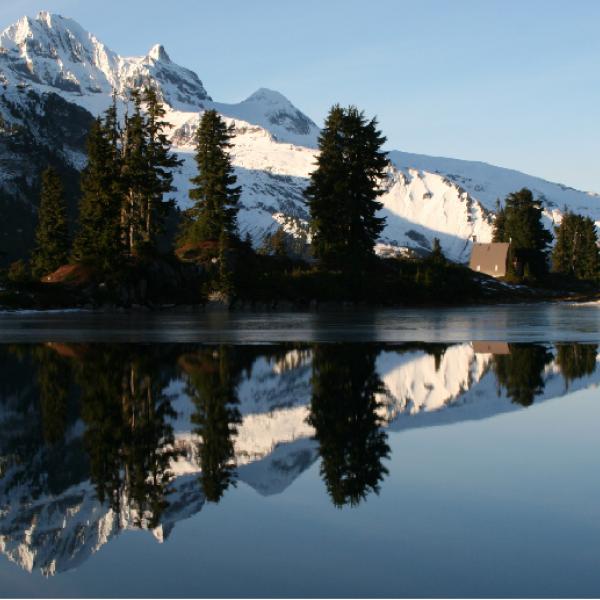 Montagnes enneigées avec un lac à l’avant-plan