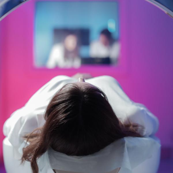 Une vue du sommet de la tête d’une femme à travers le cylindre d’un appareil d’imagerie médicale