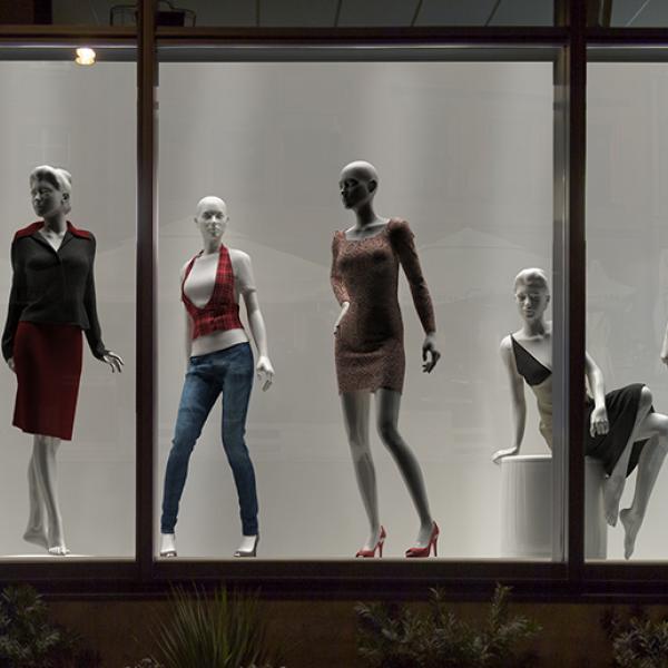 A group of mannequins in a window display.