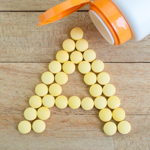 A bottle spills out yellow tablets in the form of the letter “A.”