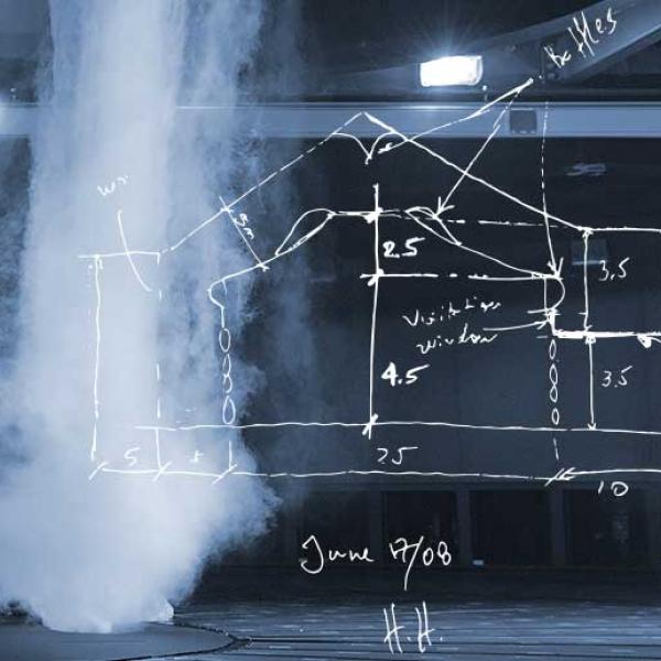 Simulation d’une tornade, telle une colonne de brouillard matinal, qui est propulsée du plafond d’un vaste tunnel noir. Un croquis à la main d’un tunnel aérodynamique recouvre partiellement l’image.