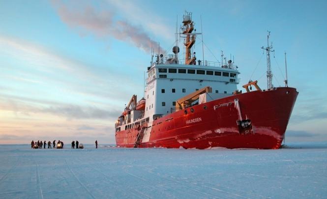 A red and white ship surrounded by ice.