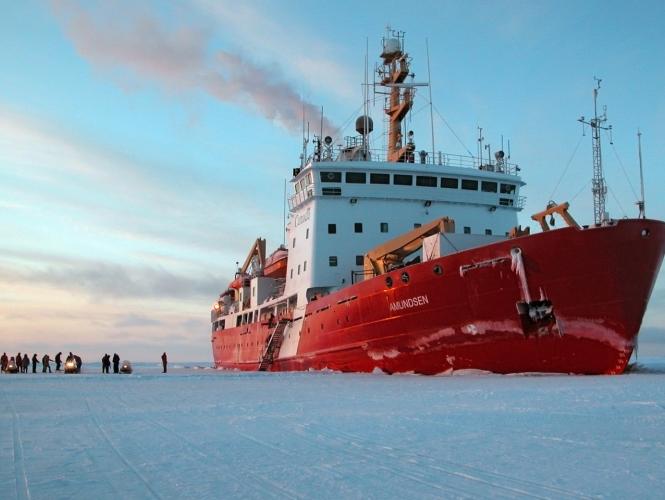 Un navire rouge et blanc entouré de glace