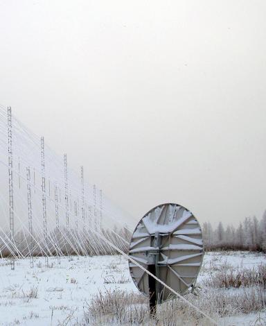 A series of tall antennae towers covered in snow.