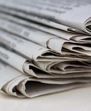 A close-up of a stack of folded newspapers