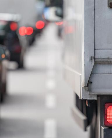 Photo en gros plan des feux arrière d'une voiture et d'un camion de transport à l'arrière d'une longue file de véhicules.