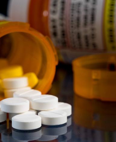 Prescription pill bottles tipped over with white tablets poured out