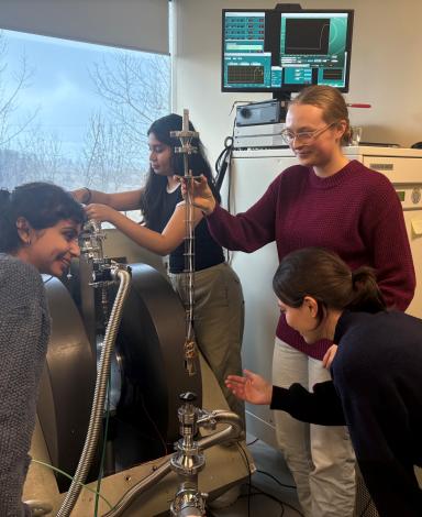 Une personne tient une longue sonde alors qu’une autre prépare une pièce d’équipement à l’arrière-plan.
