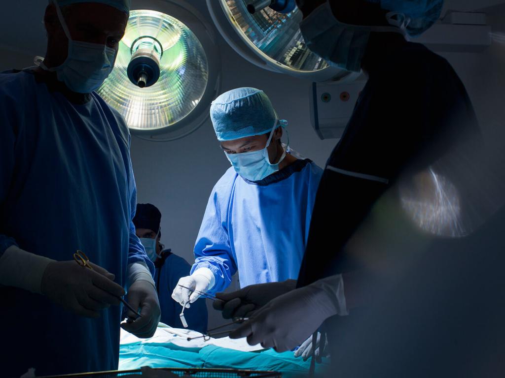 Several surgeons and nurses around an operating table.