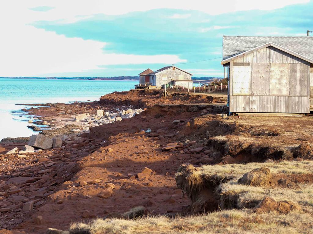 Weathered cottages perch on the edge of a ragged shoreline in Prince Edward Island that was badly eroded by Hurricane Fiona.