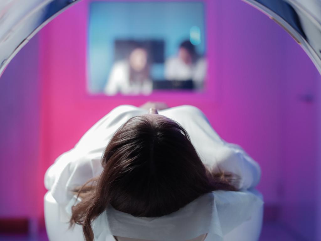 Une vue du sommet de la tête d’une femme à travers le cylindre d’un appareil d’imagerie médicale