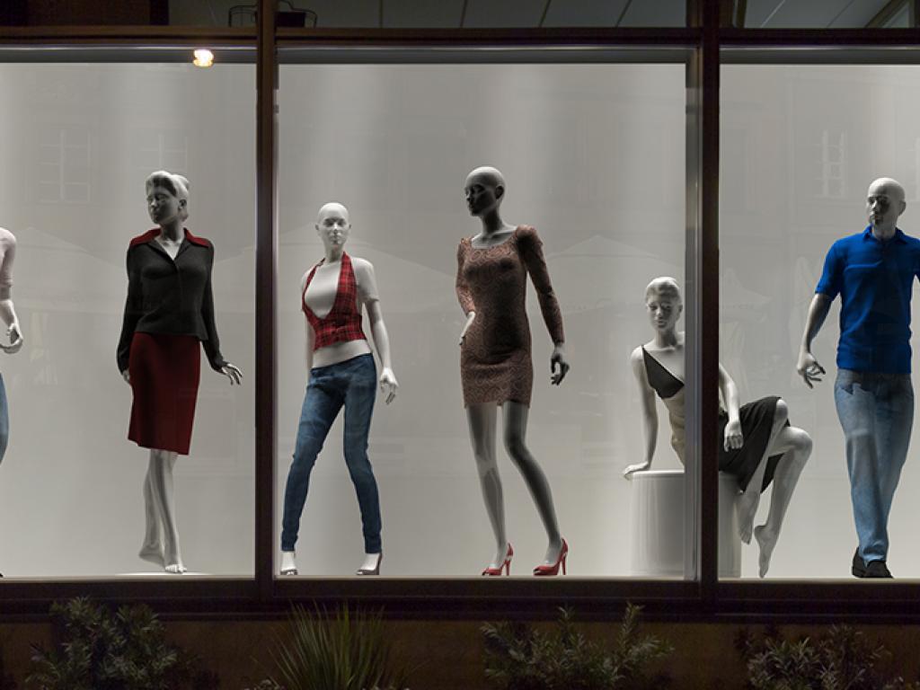 A group of mannequins in a window display.