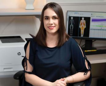 A person sitting at a desk, posing for a photo.