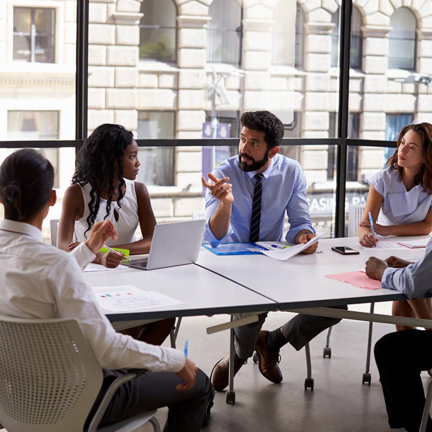 A group of people in discussion sitting around a conference table