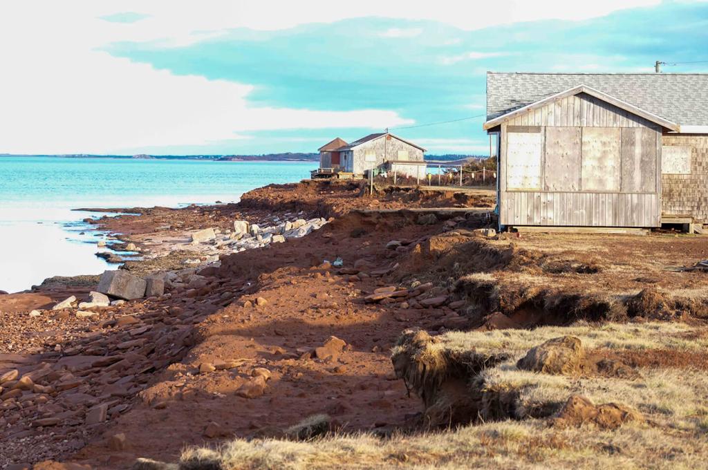 Weathered cottages perch on the edge of a ragged shoreline in Prince Edward Island that was badly eroded by Hurricane Fiona.