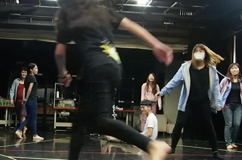 Des élèves d’art dramatique en mouvement sur une scène.