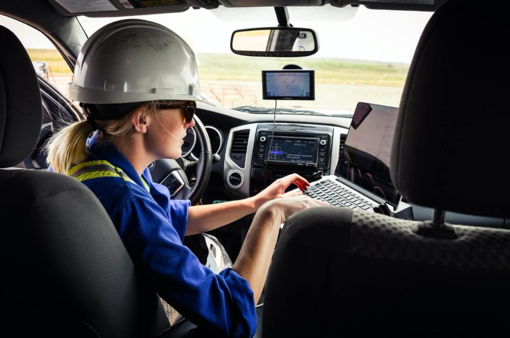 Assise derrière le volant d’un véhicule, une jeune chercheuse coiffée d’un casque de protection tape sur un ordinateur portable.