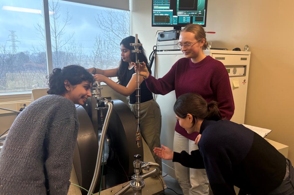 A person holds a long probe while another prepares another piece of equipment in the background.