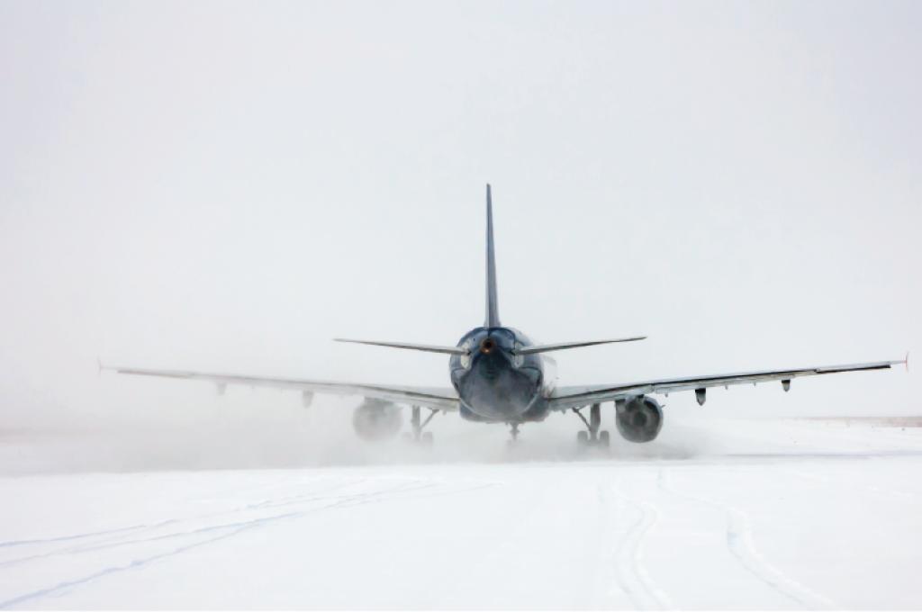Vue arrière d’un avion sur un sol enneigé.