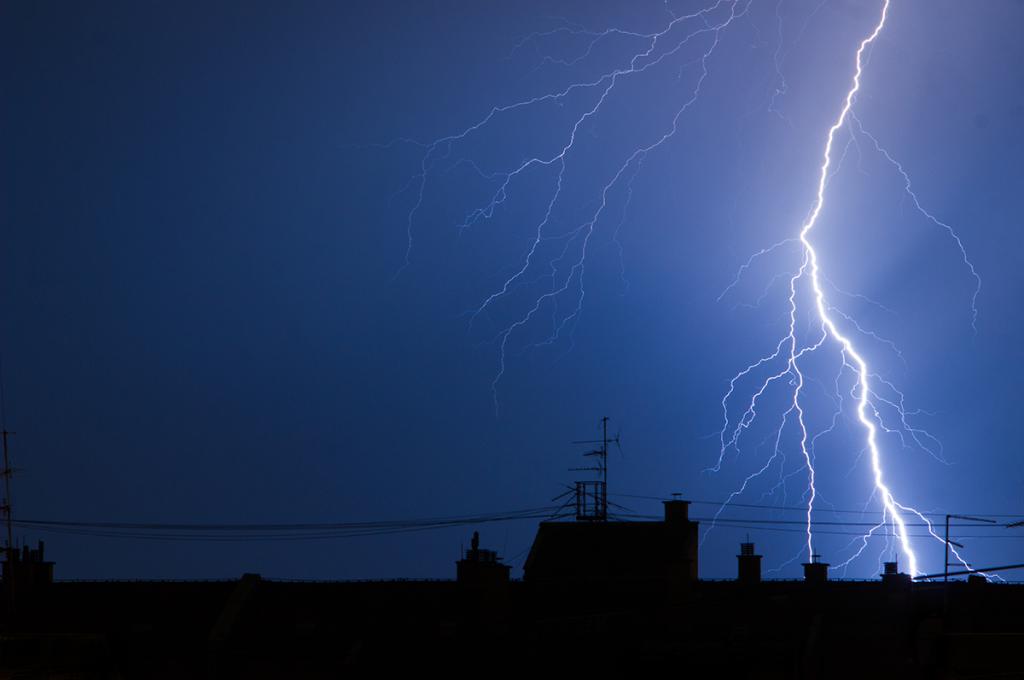 Lightning arcs between two skyscrapers in a nighttime city scape