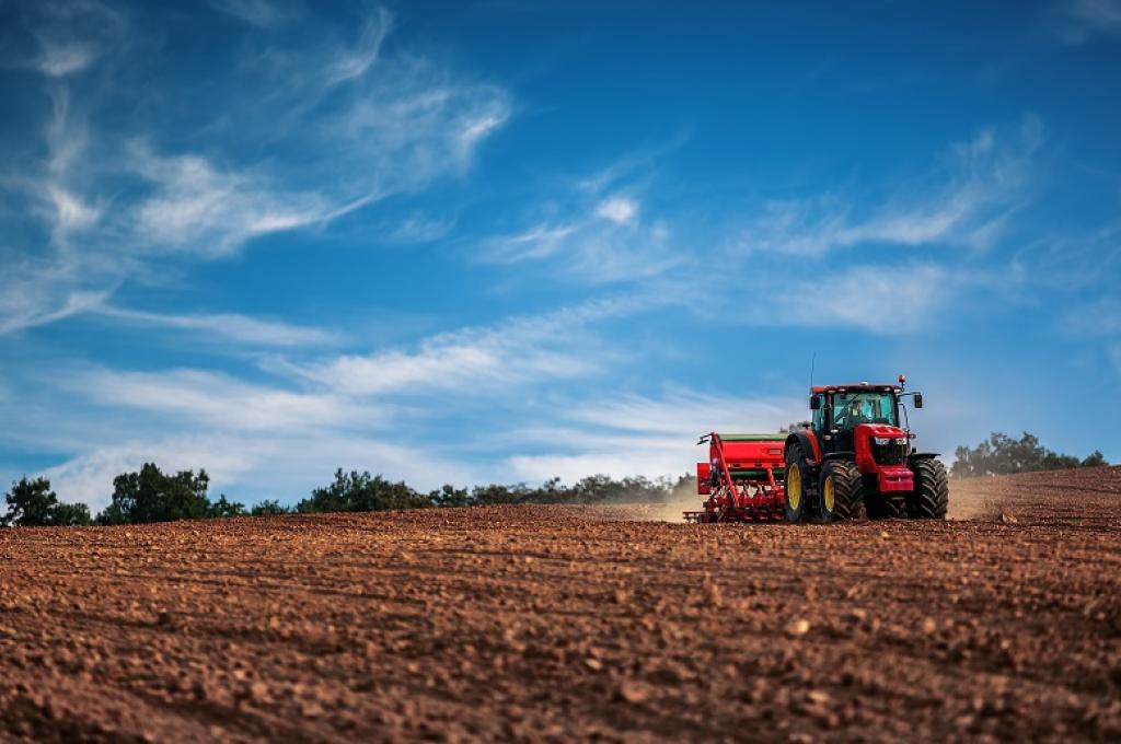 Tracteur en marche sur un champ stérile.