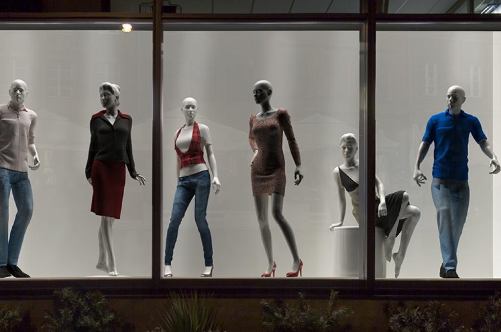 A group of mannequins in a window display.
