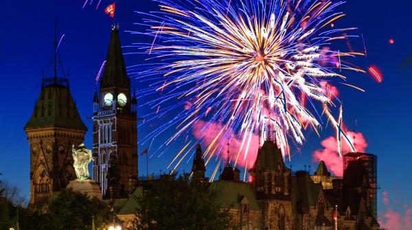 Une vue de la colline du Parlement d'Ottawa avec des feux d'artifices dans l'arrière-plan